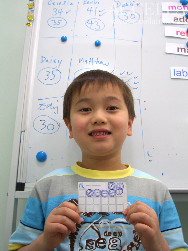 Kevin holding his Accella rewards card and standing in front of the points tally for last Saturday's P2 lesson.