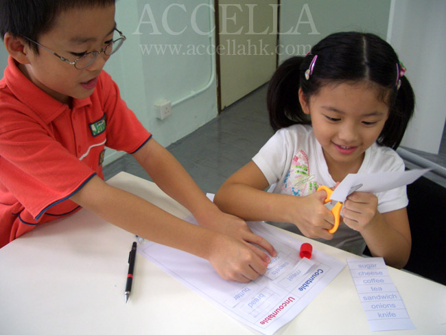 BryanF and CharlotteY sorting countable and uncountable nouns during a hands-on grammar activity in one of our P2 classes.